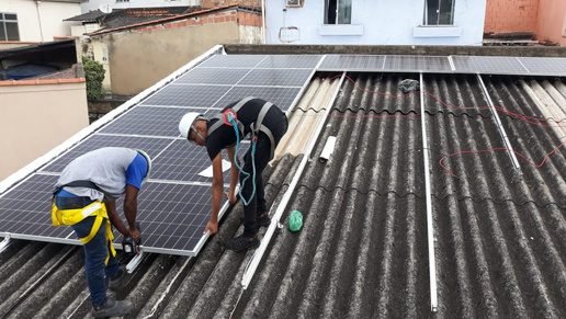 Equipe técnica instalando estrutura de fixação de painéis solares em telhado